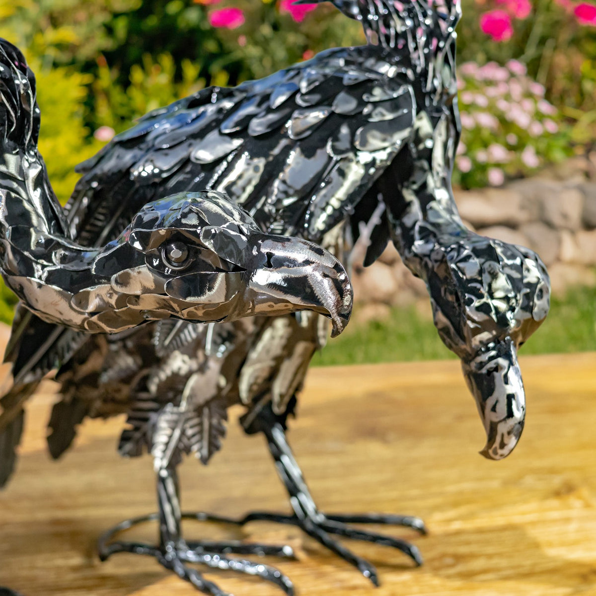 Close view of metallic vulture figurines with layered feathers and long legs