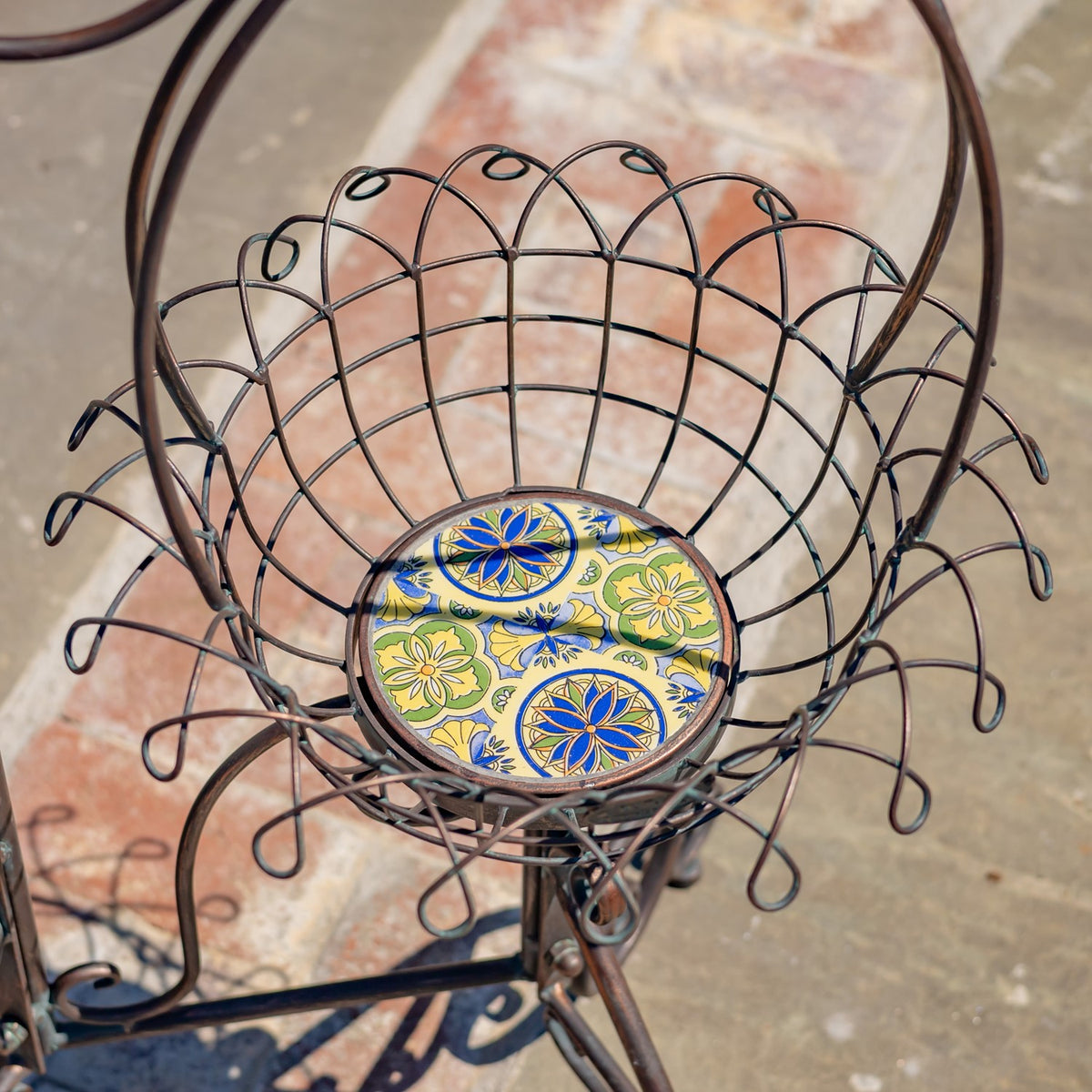 Overhead view into an empty decorative wire basket with a blue, yellow, and green patterned insert.