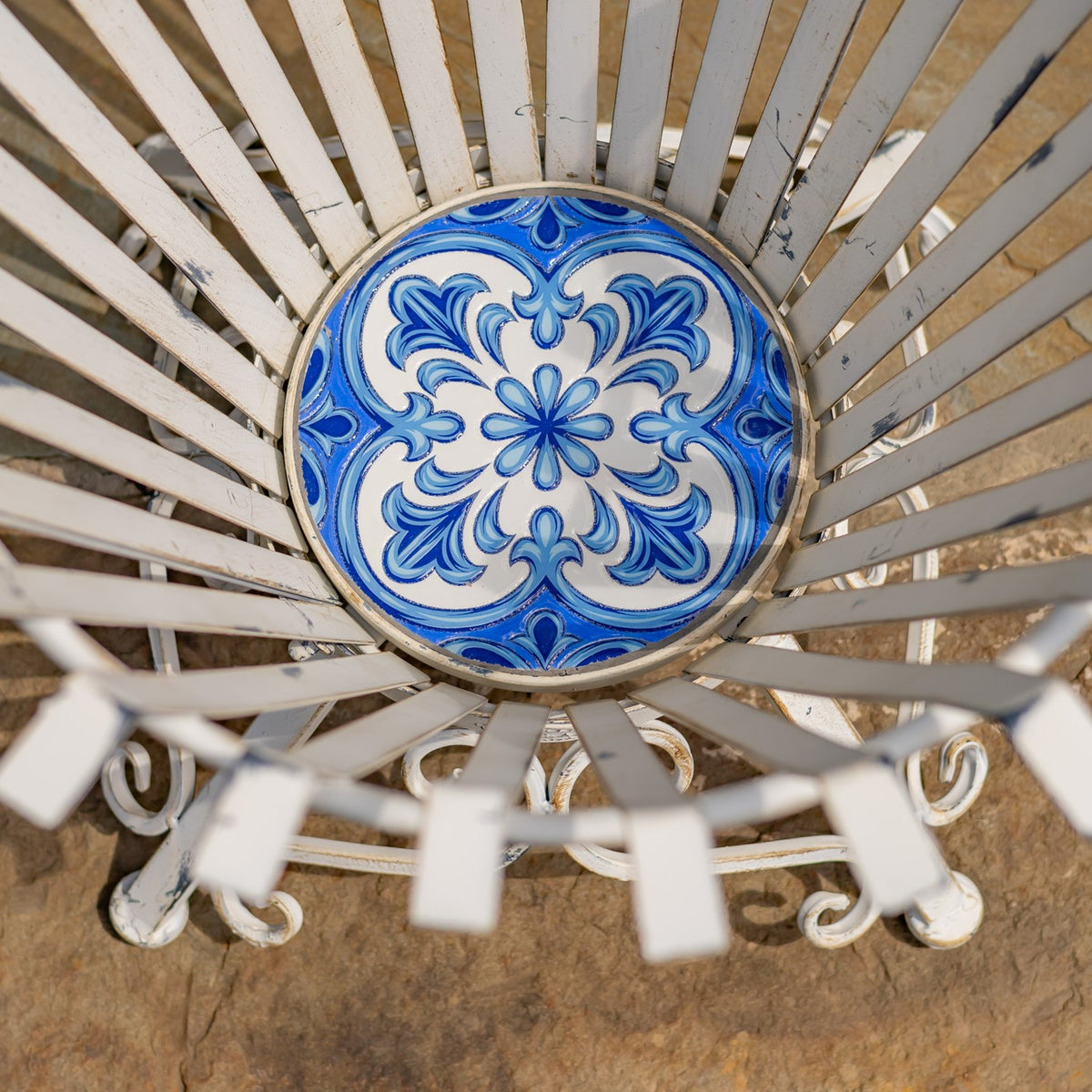 View down into the holder, showing its round blue-and-white floral mosaic base and radiating metal slats.