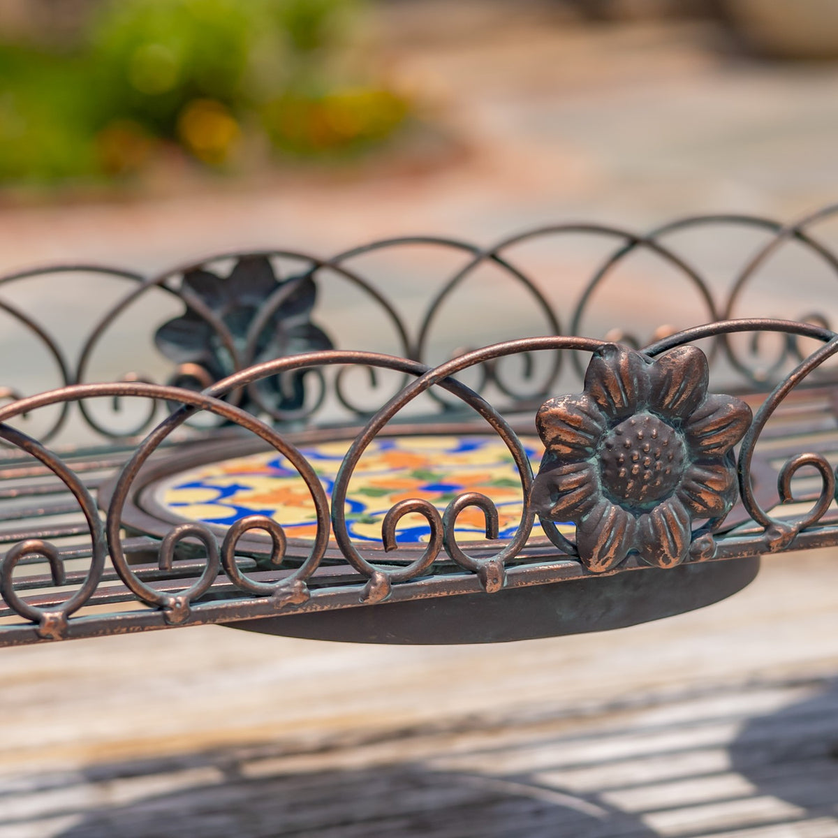 Close-up of the tray’s looping metal border, raised flower ornament, and colorful mosaic surface.