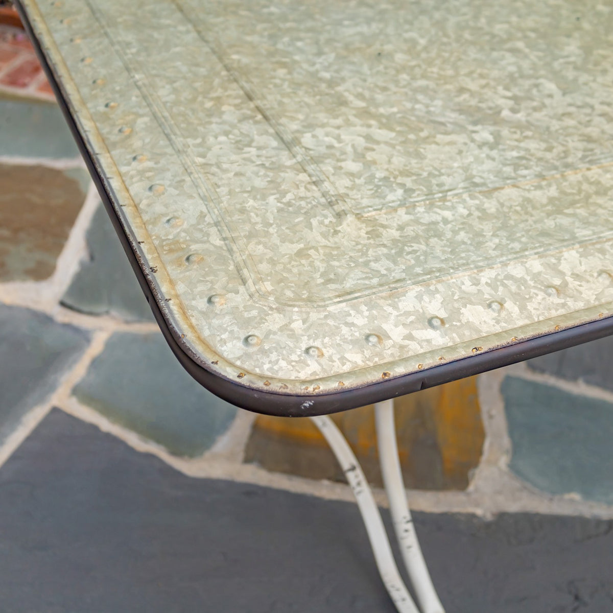 Close-up of a mottled pale tabletop with a rounded dark edge and visible -like marks.