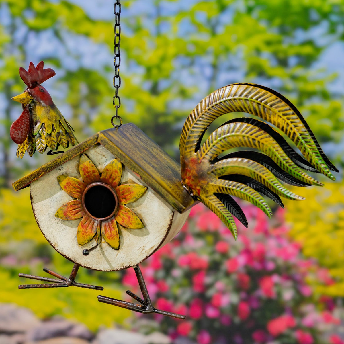 A hanging metal birdhouse shaped like a rooster, with a sunflower on its body and a curved tail.