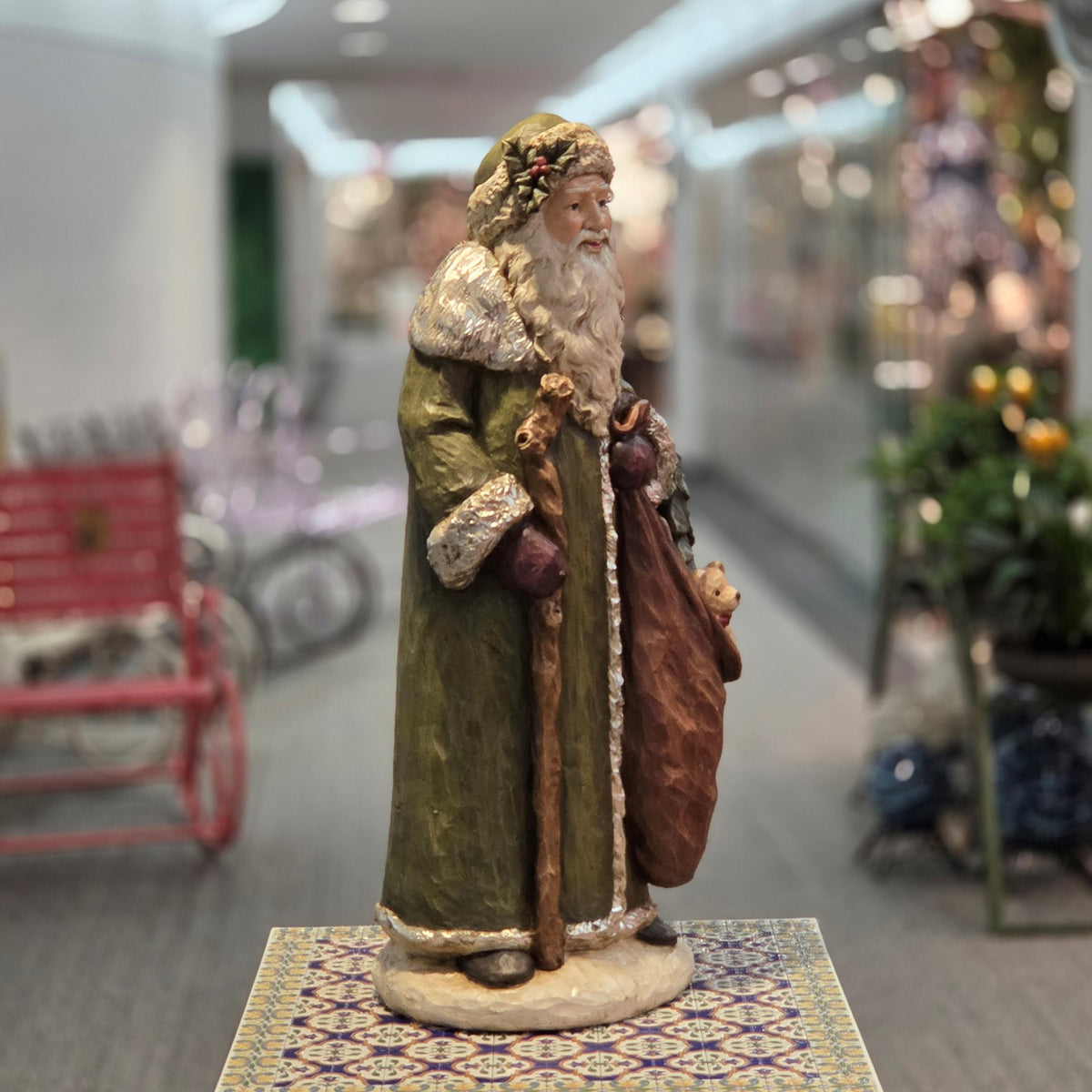 Full side view of the Santa figurine with staff and draped gift sack