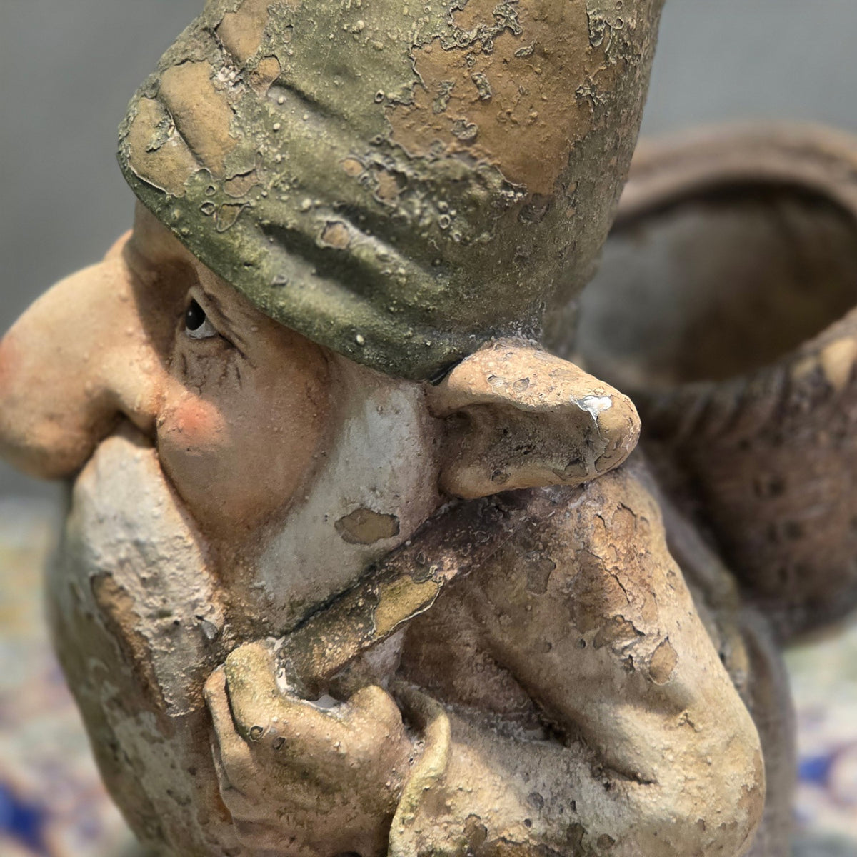 Close-up of the gnome's face and pointed hat beside the back basket planter