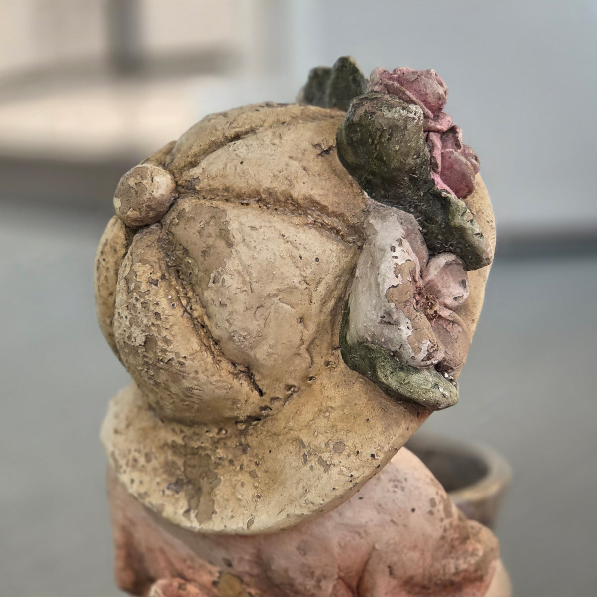 Close-up of the back of the figurine's hat with pastel flowers
