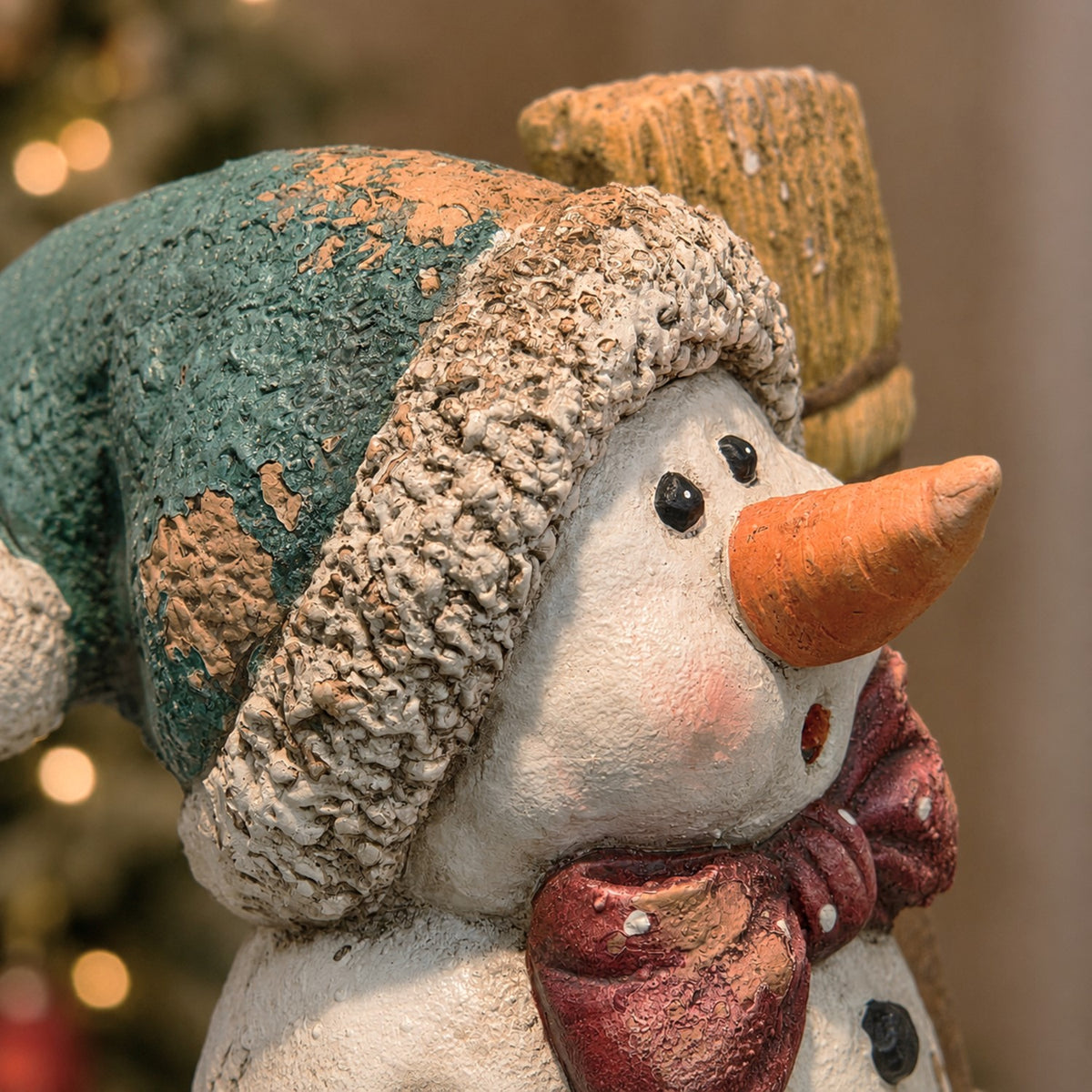 Close-up of the snowman's face, textured cap and red scarf