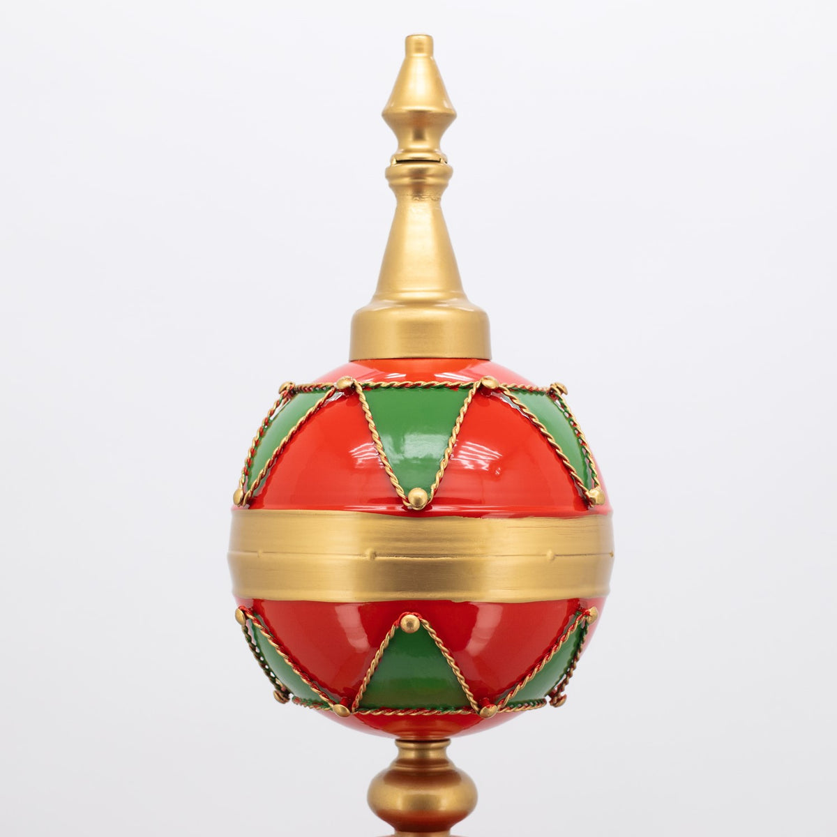 Close-up of a red ornament globe with green panels, gold trim, and a tall gold finial.