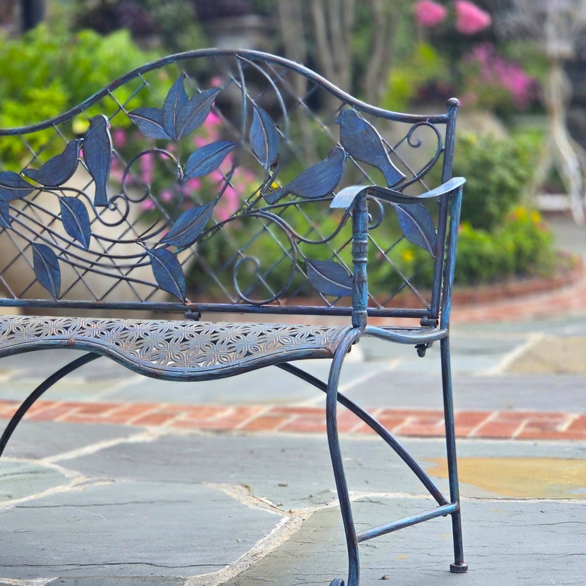 Right side of the garden bench, showing its curved seat, decorative back and legs.