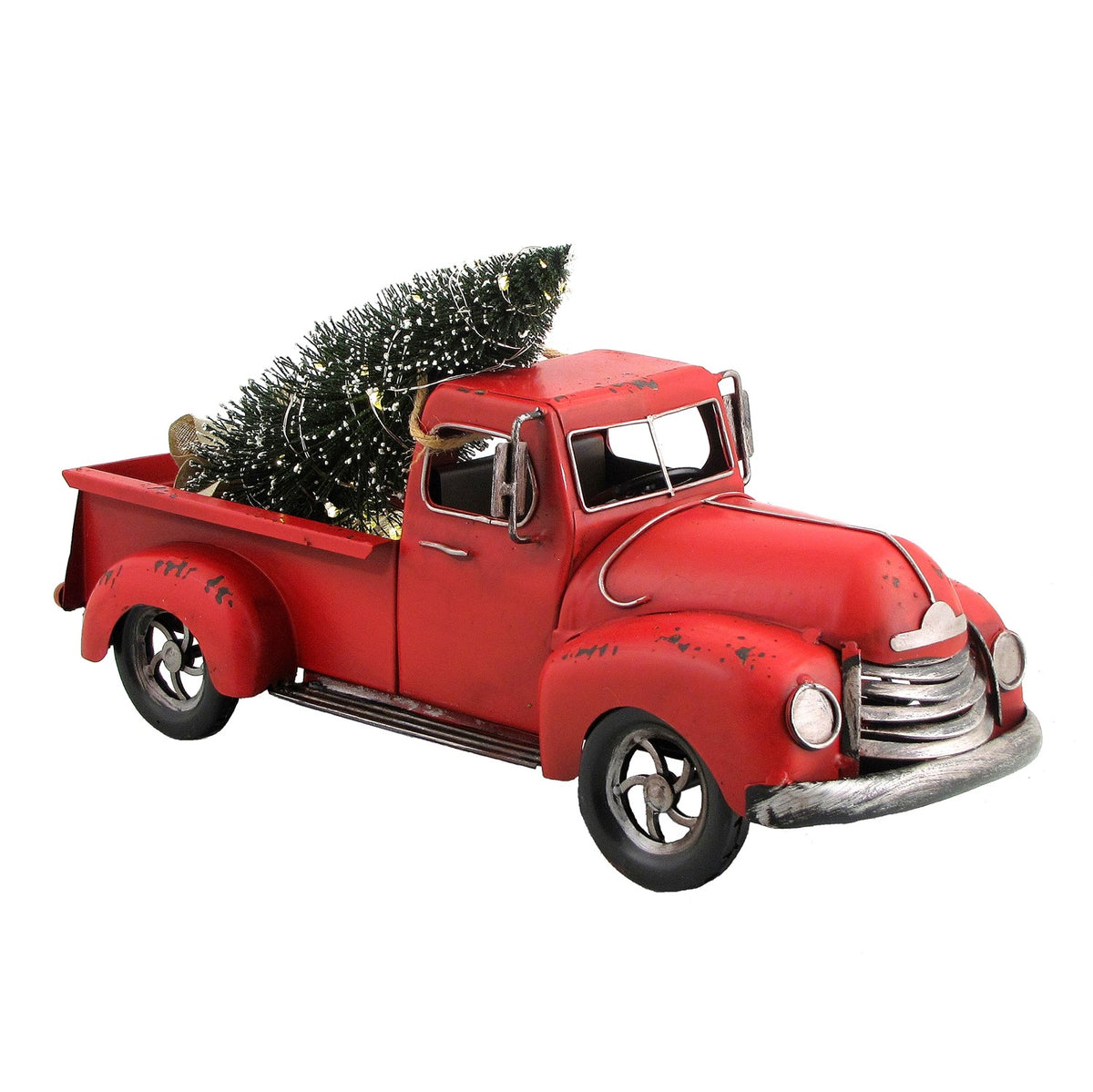 Red distressed pickup carrying a dark green tree, shown from the front three-quarter angle against white.