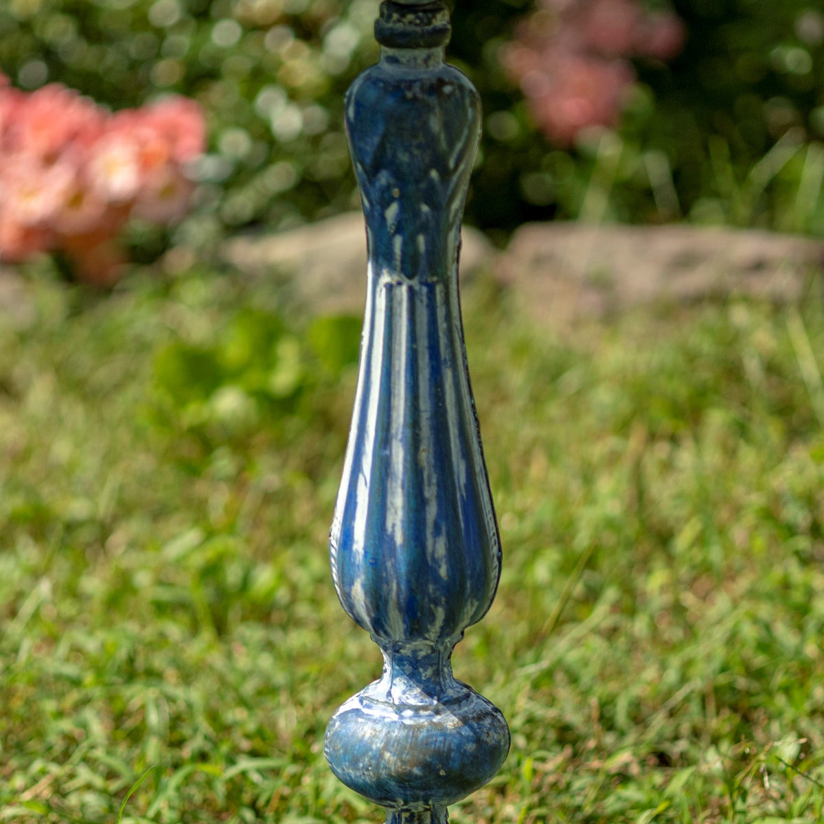 Close-up of the birdbath’s fluted blue pedestal with a rounded decorative base section.