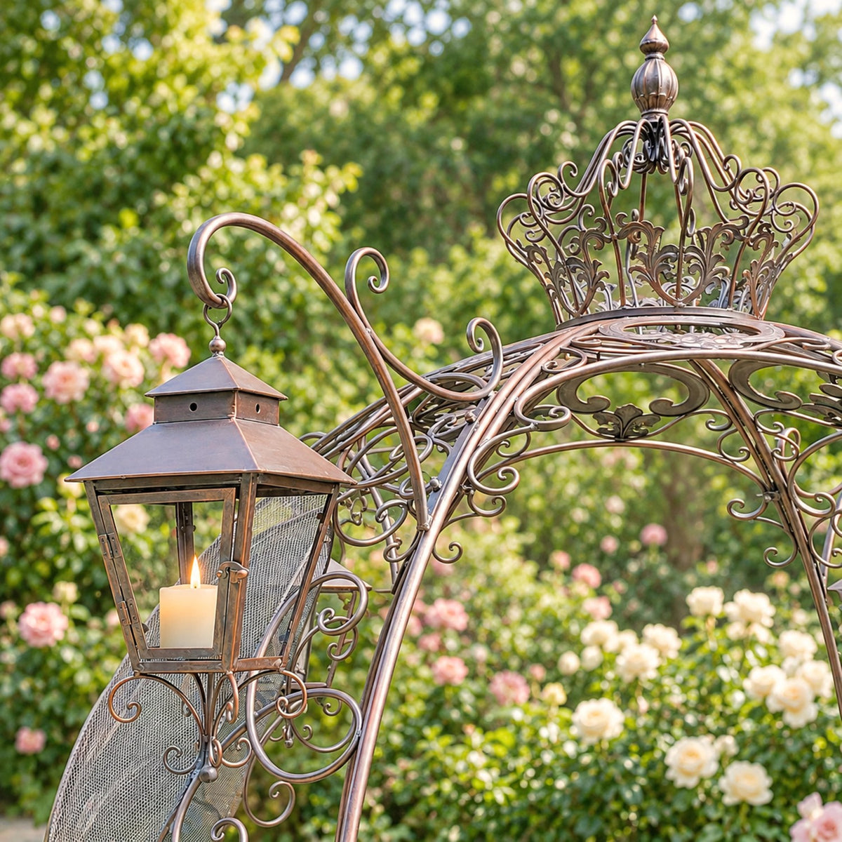 Close view of the ornate metal carriage arch, crown, and lantern among garden flowers.