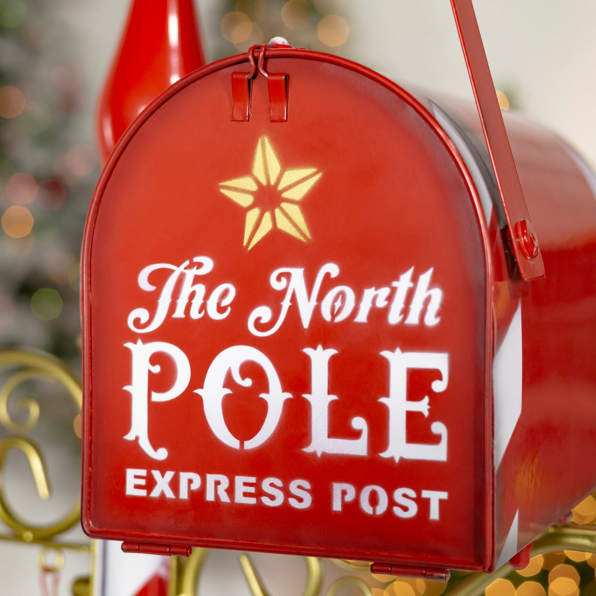 Close-up of the red arched mailbox front, decorated with a gold star and white lettering.