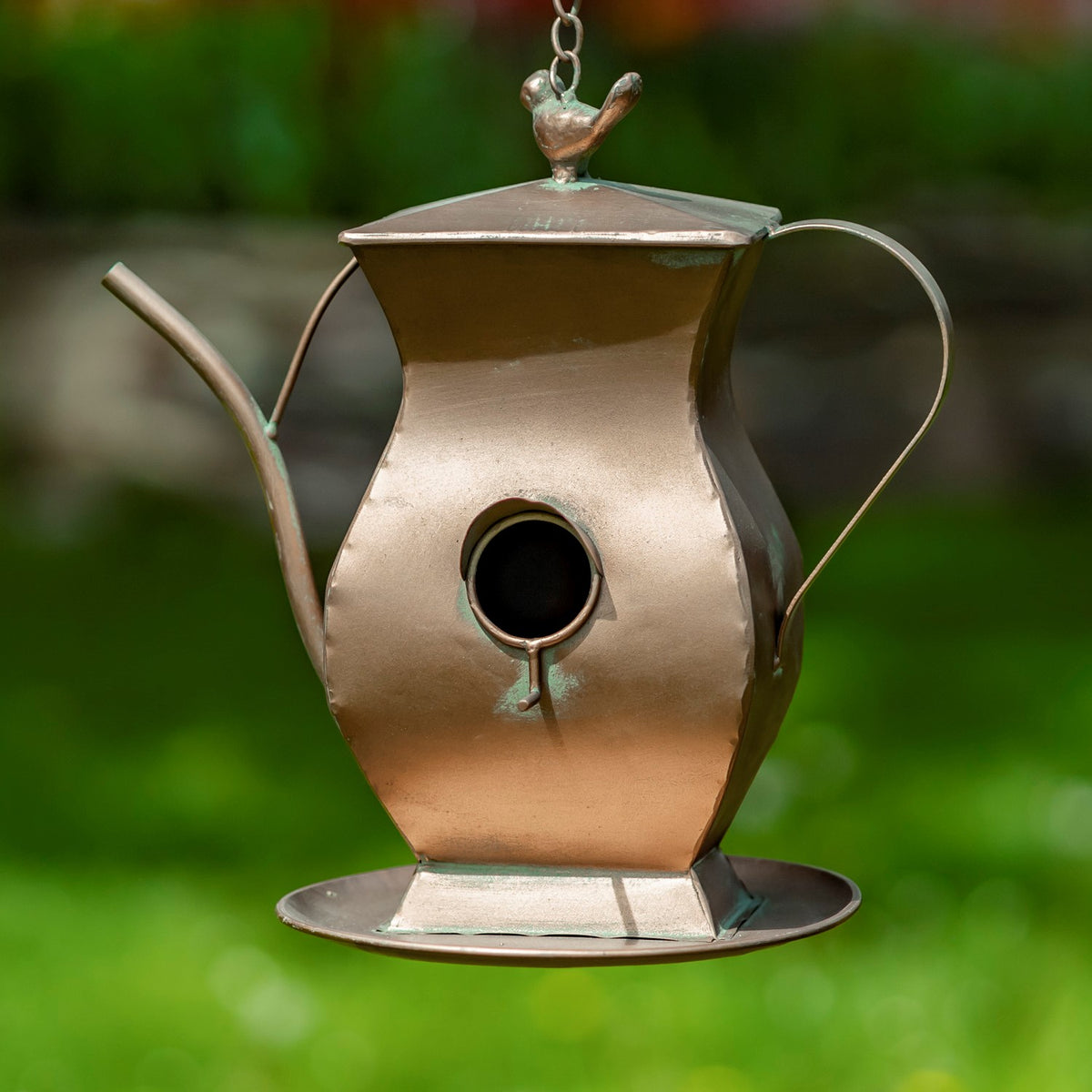 Angular copper-toned teapot birdhouse with a long spout, curved handle, round entrance and bird finial.