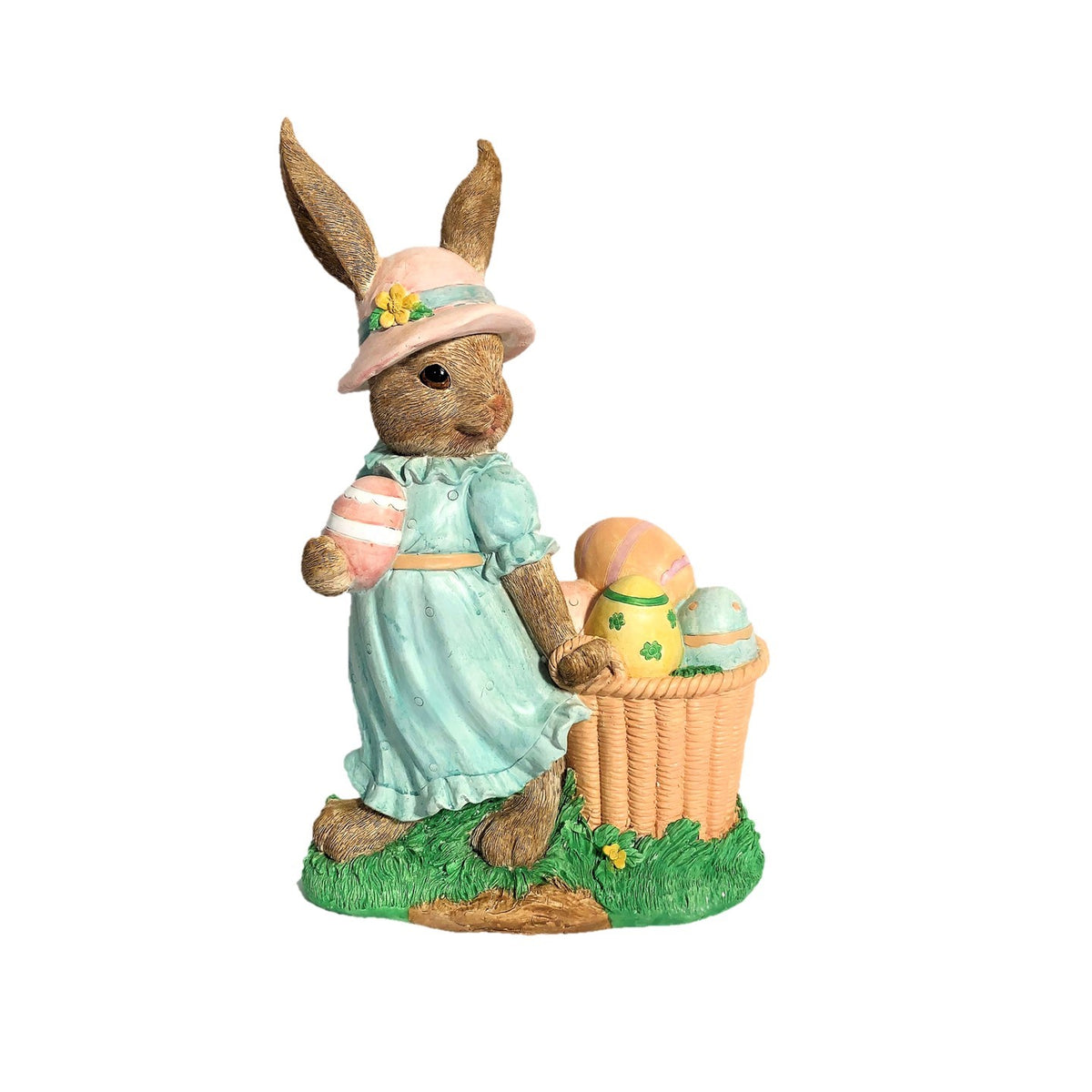 Rabbit statue in a pink hat and aqua dress, holding a striped egg beside a basket of painted eggs.