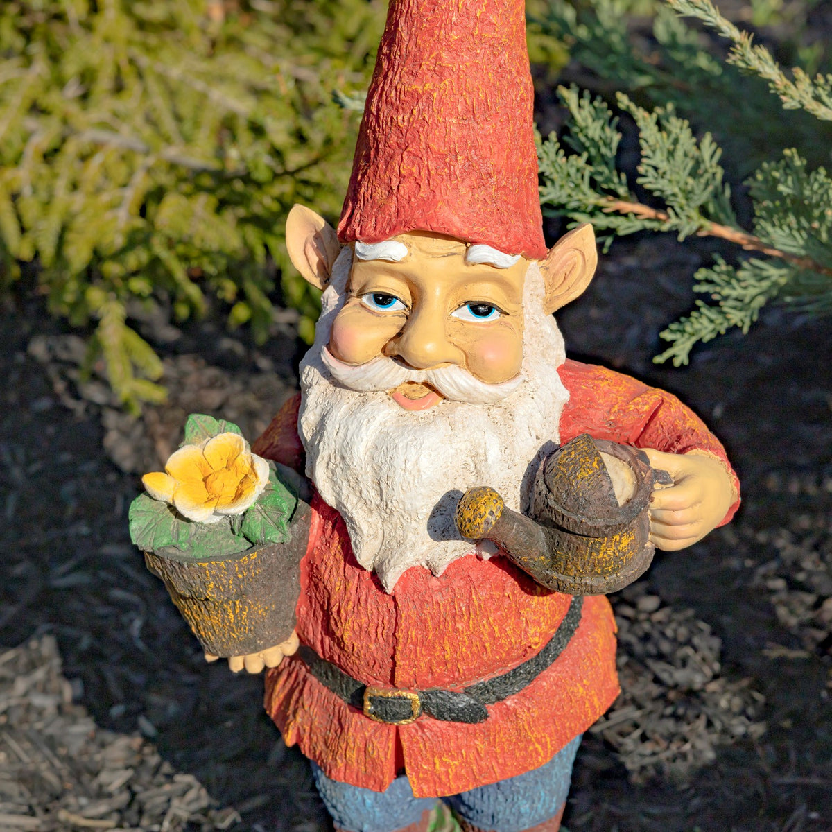 Garden gnome facing forward with a white beard, a yellow flower in a pot, and a watering can.