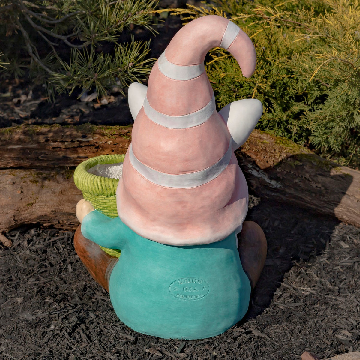 Rear view of the pink-hatted gnome, with a striped hat and teal outfit.