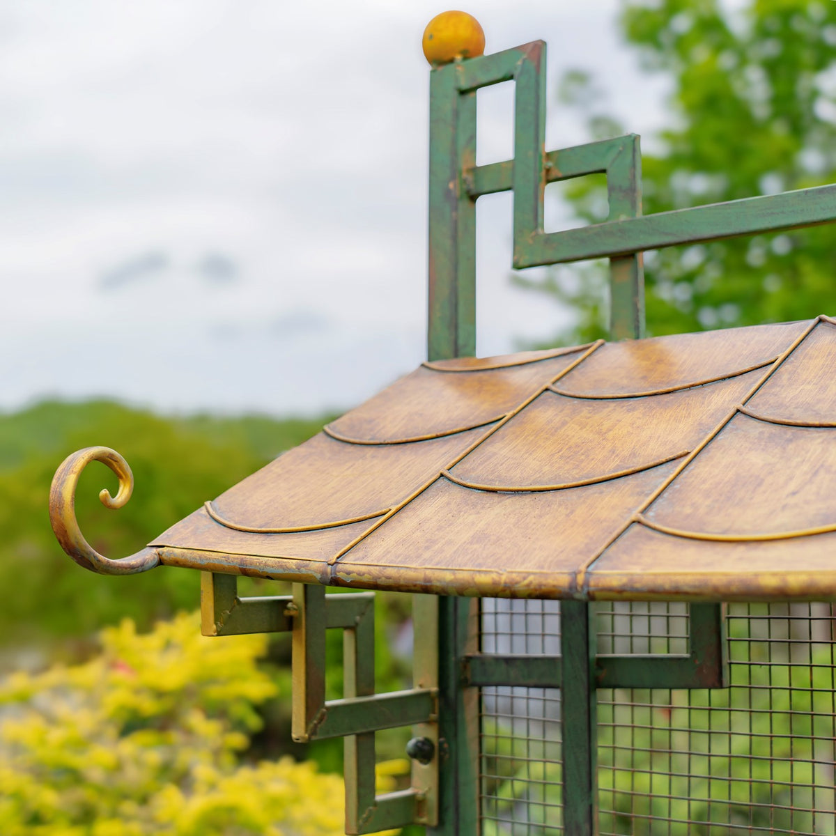 Gold-toned scalloped roof panels with a curled edge beneath a green metal frame.
