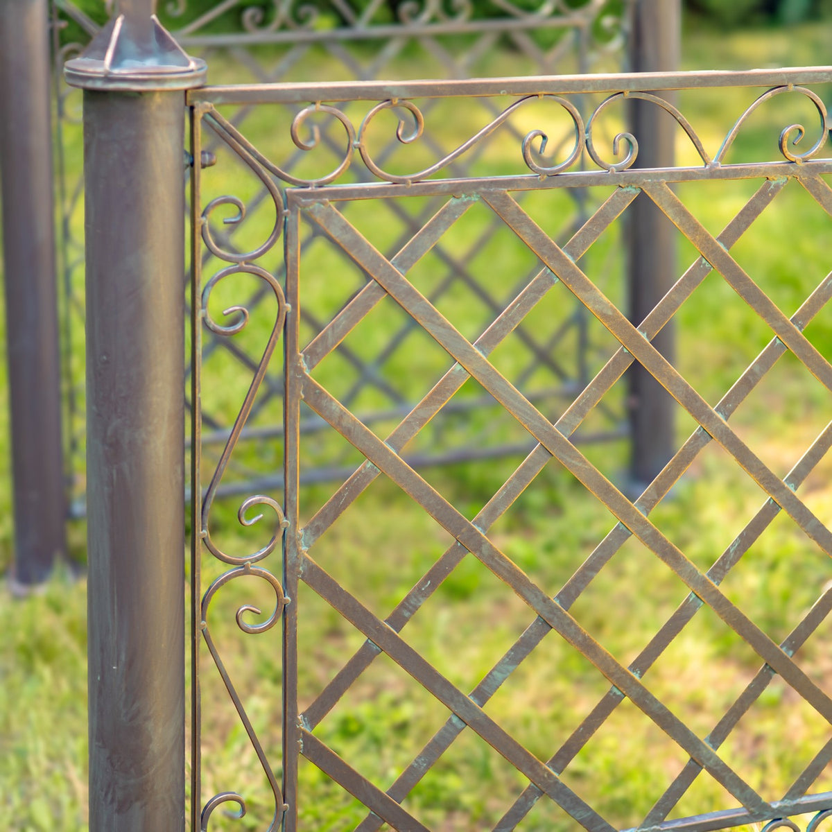 Close-up of a cylindrical iron post beside a diamond-lattice panel with decorative scrollwork along its edge.