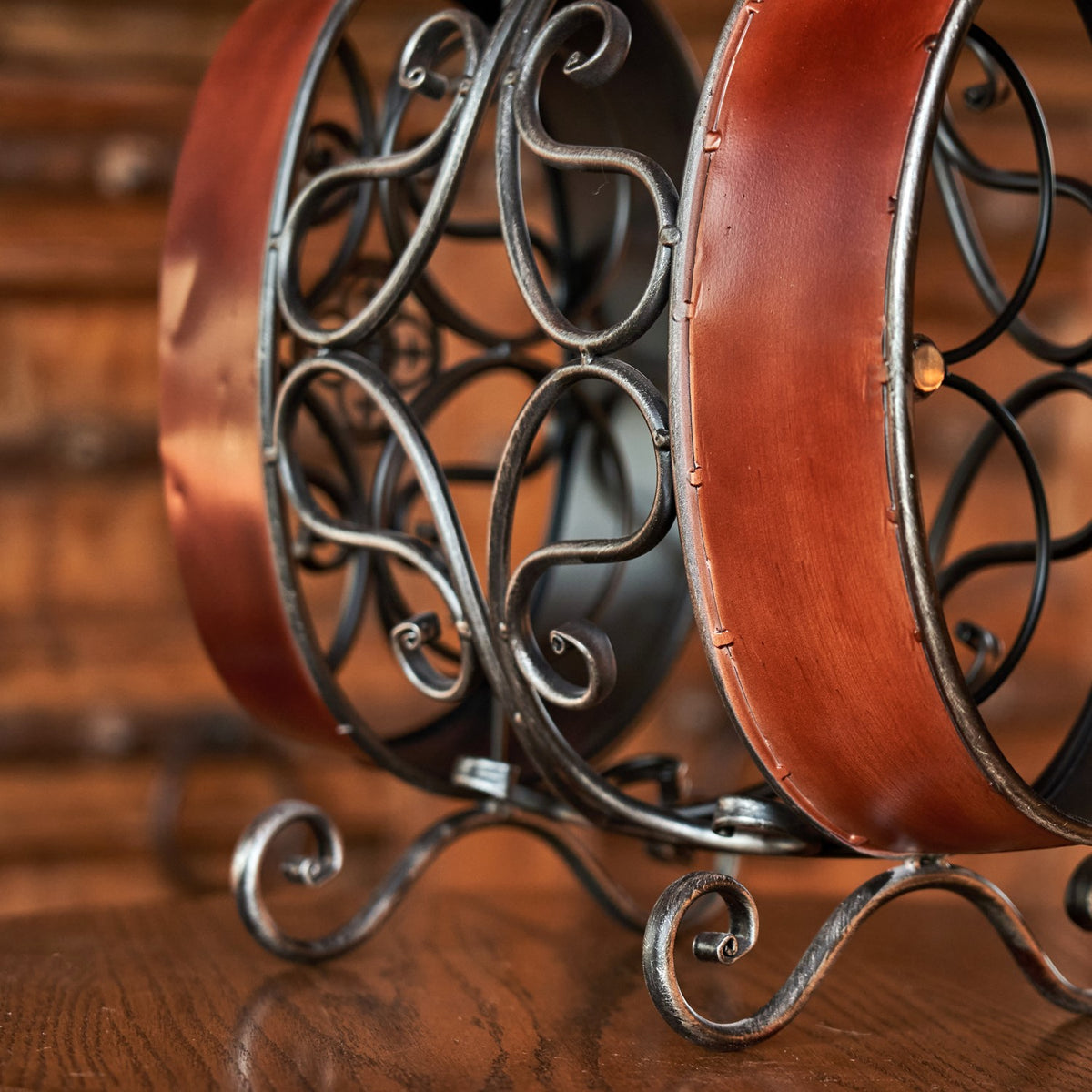 Close view of the rack’s curled metal supports, reddish-brown curved side, and decorative feet.