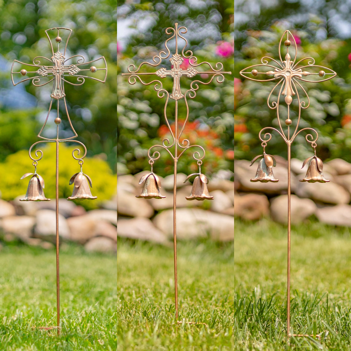 Three ornate garden stakes with different cross designs and pairs of hanging bells stand in a grassy garden.