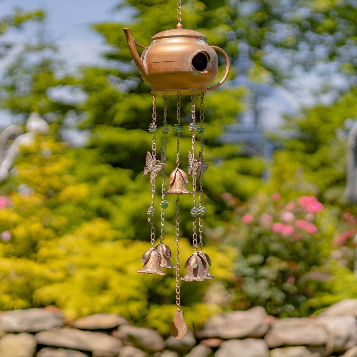 Low, rounded teapot birdhouse wind chime with a side handle, bird ornaments, and hanging bells.