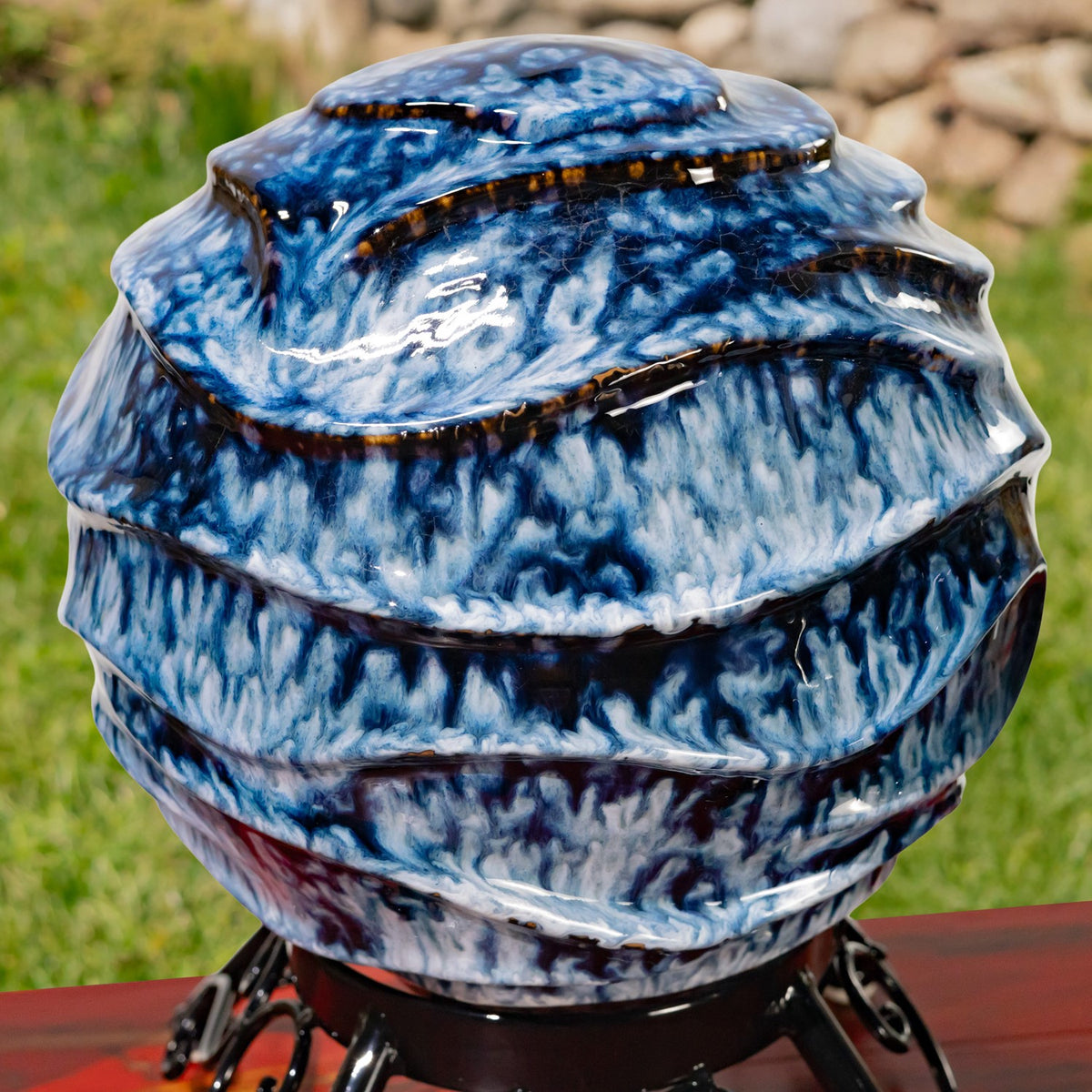 Close-up of a glossy blue-and-white gazing globe with raised, irregular ridges.