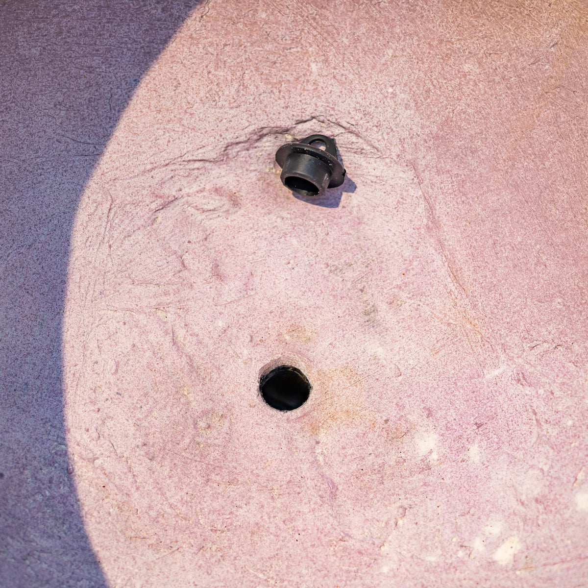 Close-up of the pot’s pinkish underside with two dark openings.