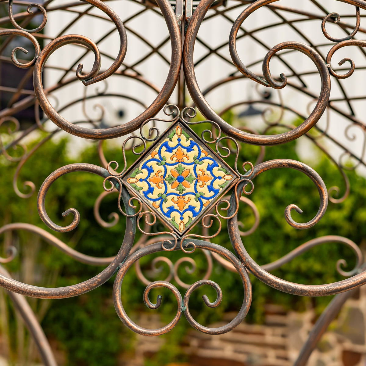 A colorful square mosaic tile sits among the bridge’s ornate curling metal scrollwork.