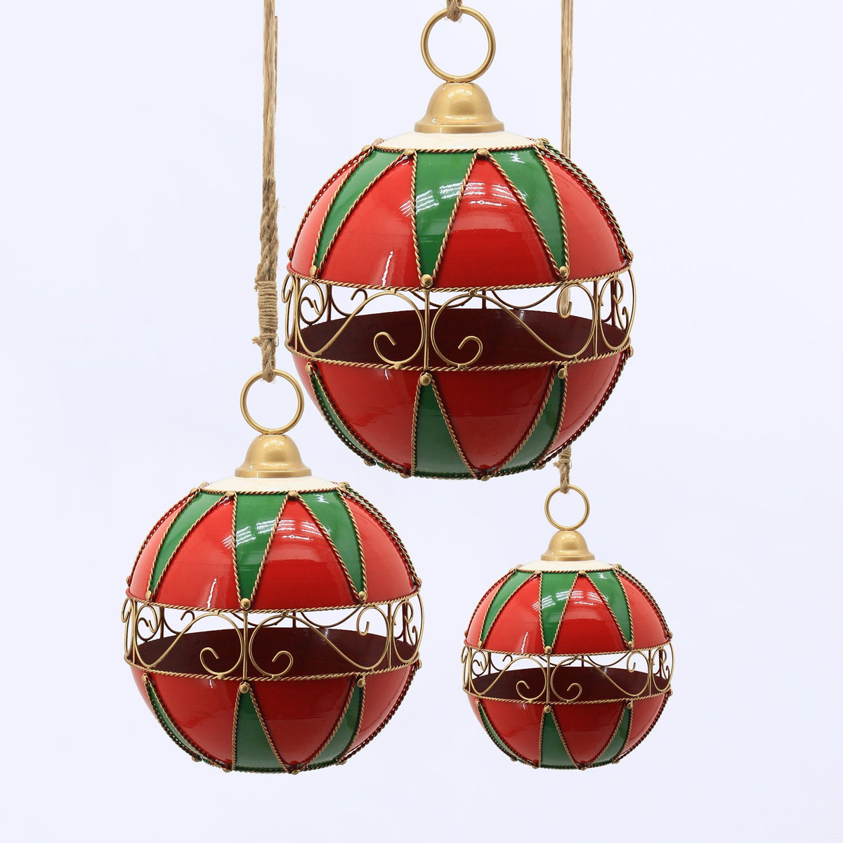 Three red and green hanging ornaments in different sizes, each with a gold scrollwork band.