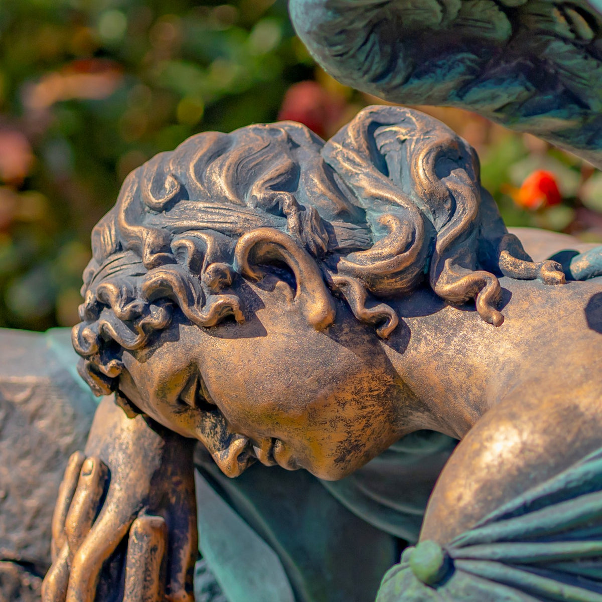 Close-up of the sleeping angel’s bowed face, curled hair, and hand resting near her head.