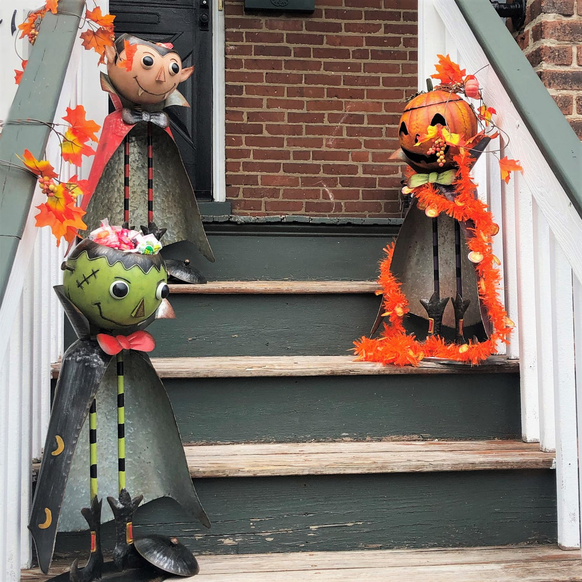 Green monster, vampire, and pumpkin figures decorate an outdoor staircase.