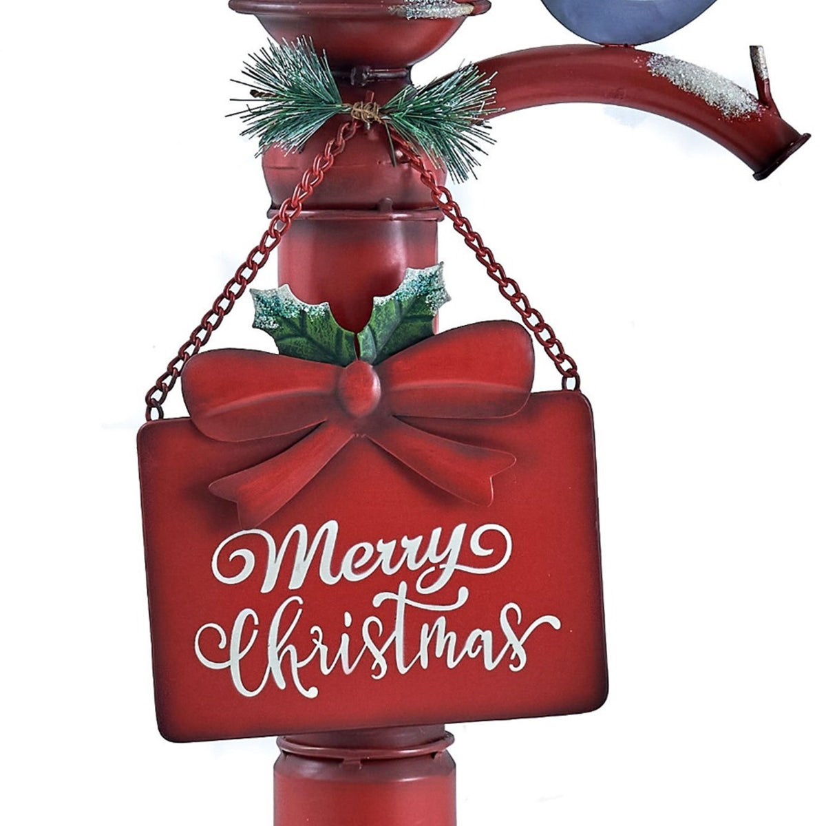 Close-up of the red hanging sign, bow, holly leaves, and chain beneath the pump.