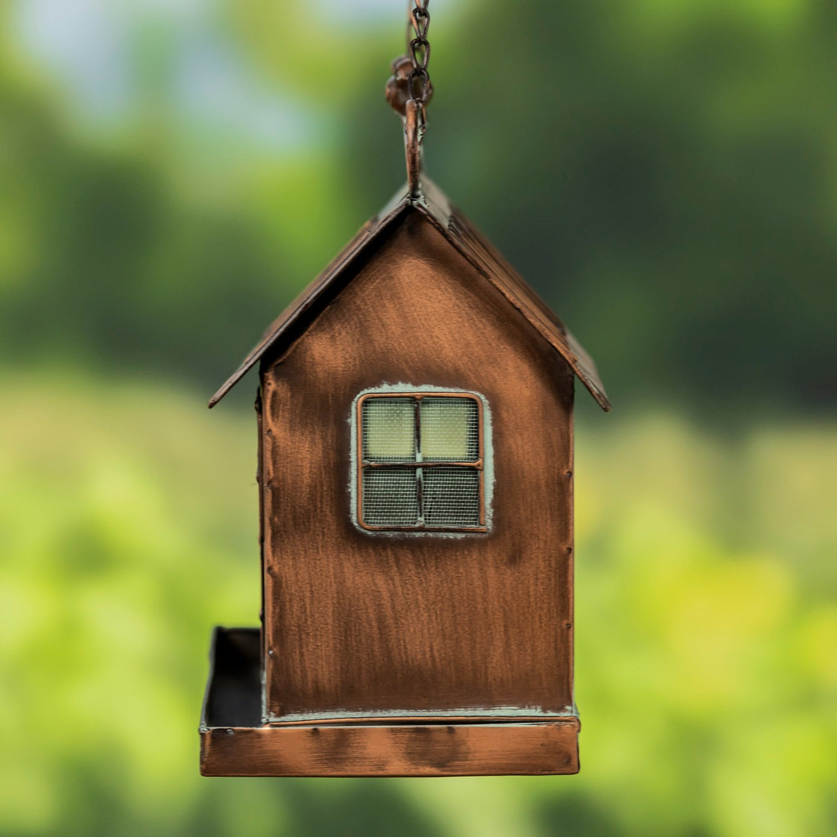 Angled side view of the feeder, showing its gable, mesh window, hanging chain, and base tray.