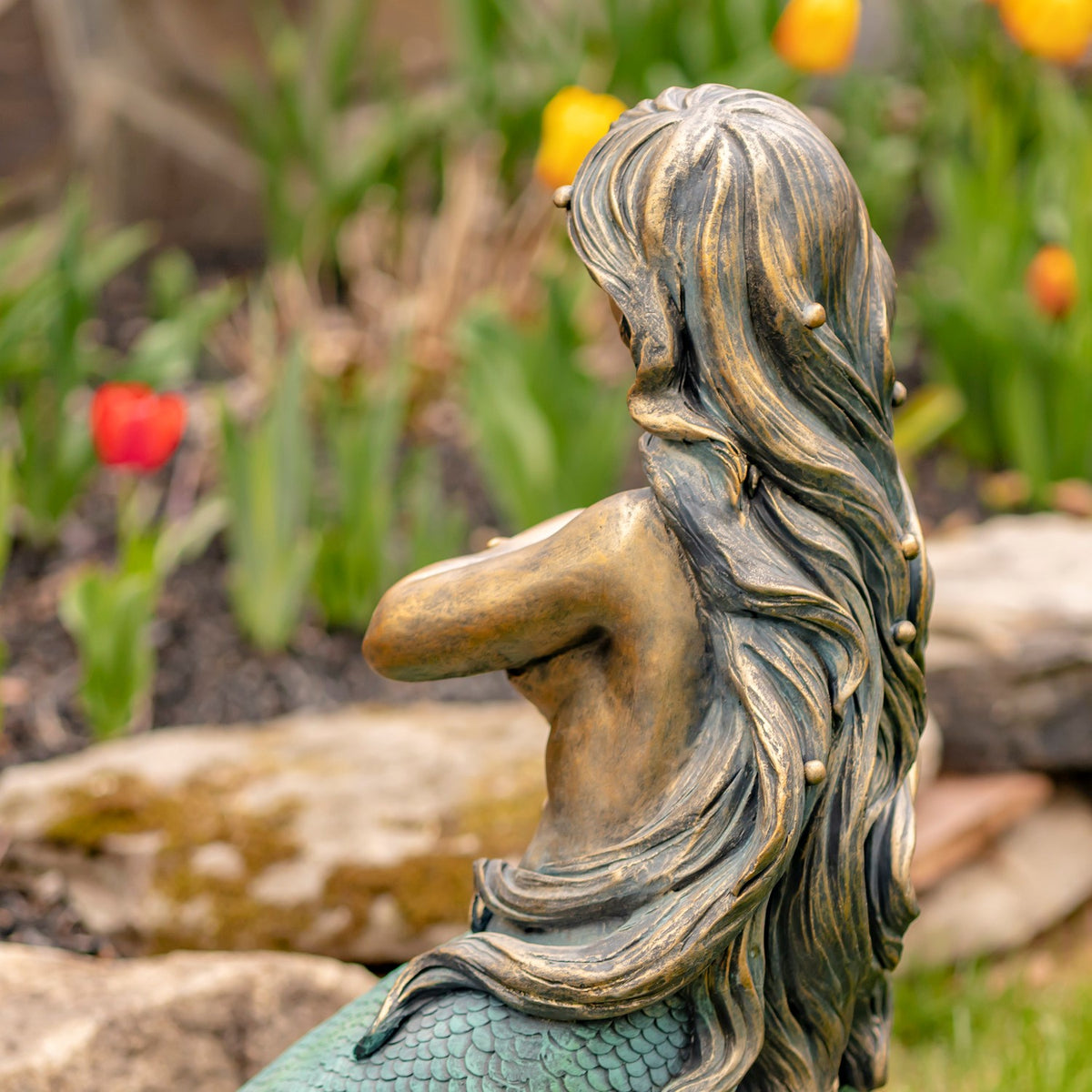 Close view of the mermaid's wavy hair, upper body, and patterned tail scales.