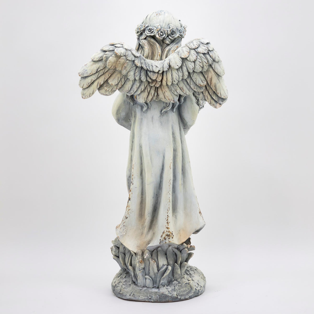 Full-length rear view highlighting the angel’s feathered wings and the folds of its robe.
