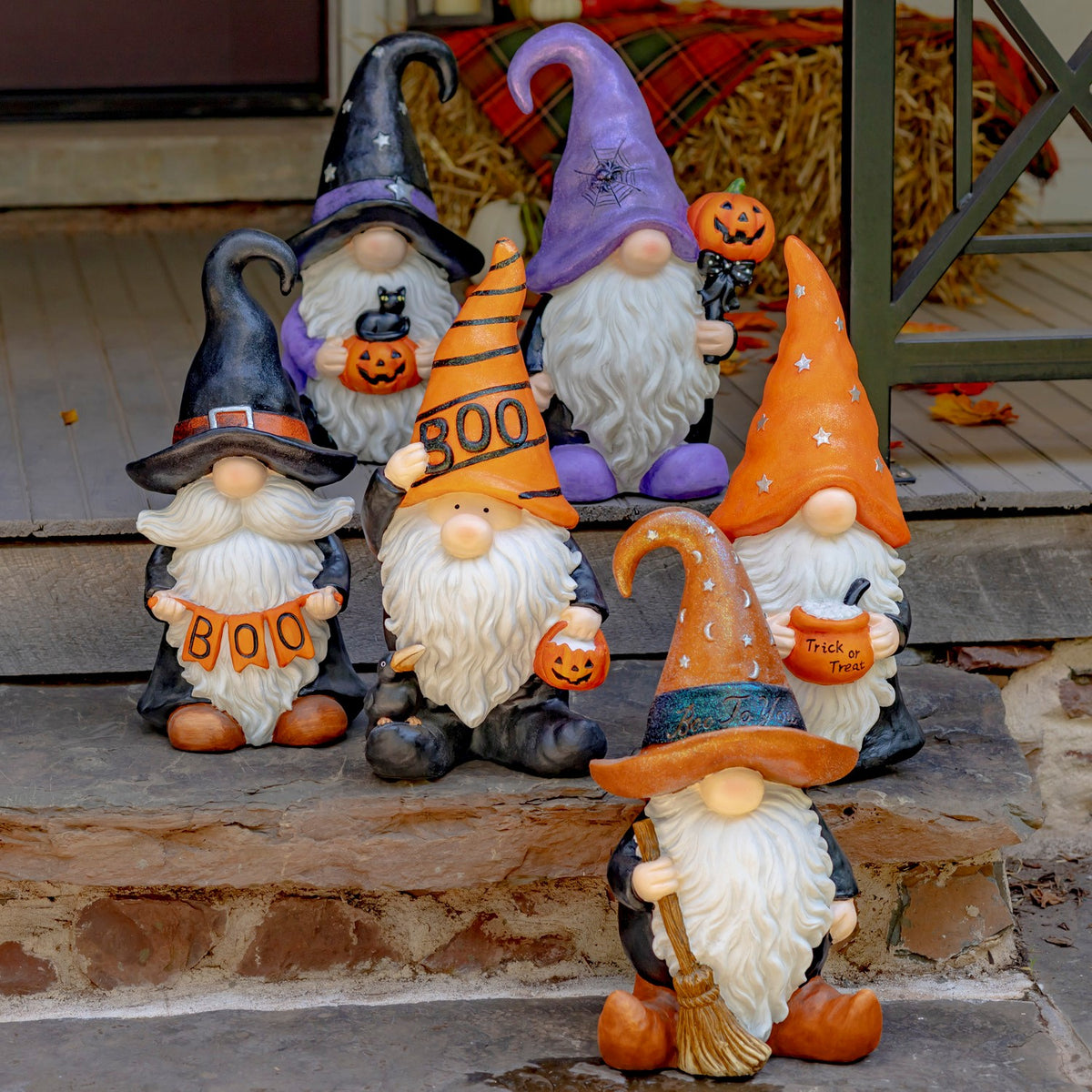 Six colorful Halloween gnomes with pointed hats, white beards and seasonal decorations are arranged together.
