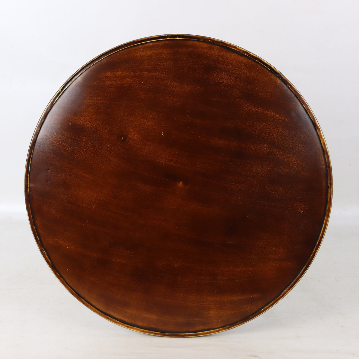 Close-up of the round tabletop, showing its warm brown surface and raised dark metal rim.