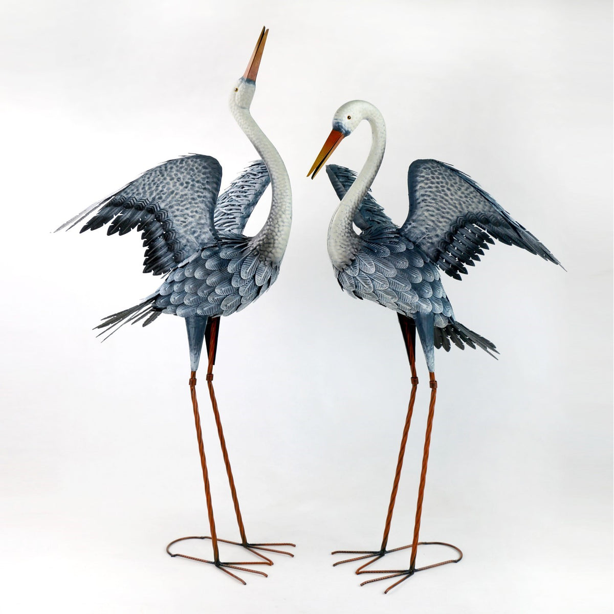A pair of spread-wing heron figures shown from another angle against a plain white background.
