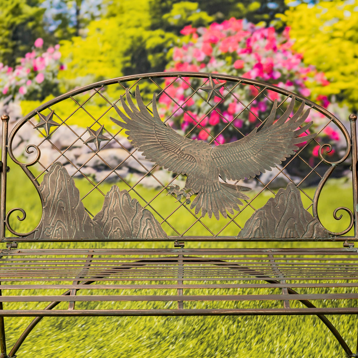 A closer view of the bench shows the eagle and mountain shapes across its lattice back above the slatted seat.