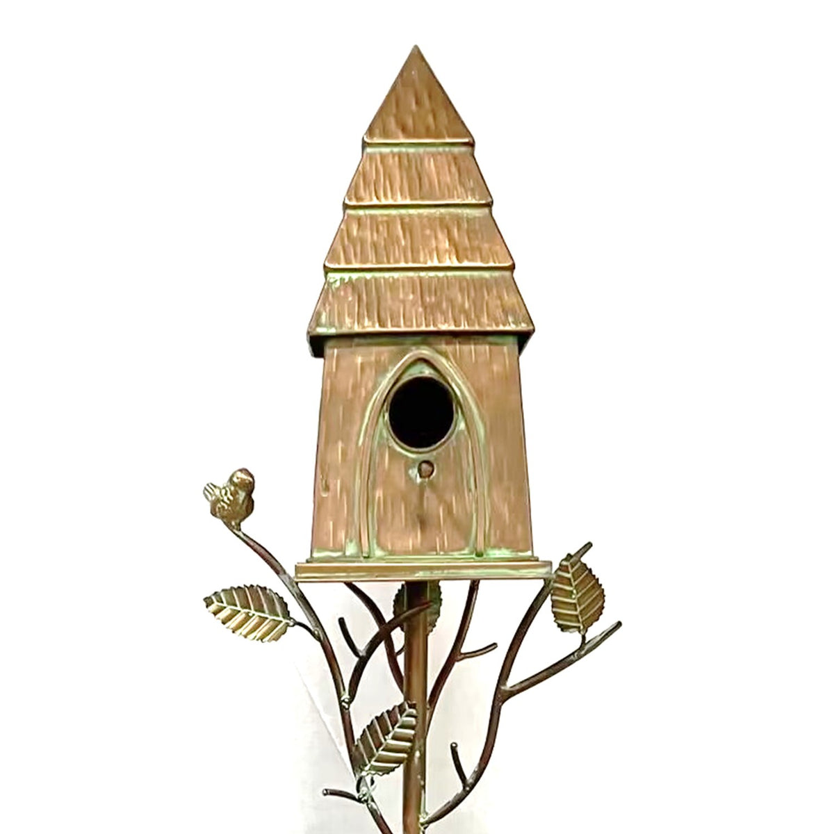 Close-up of the birdhouse’s round entrance, ridged roof, and decorative metal branches and leaves.