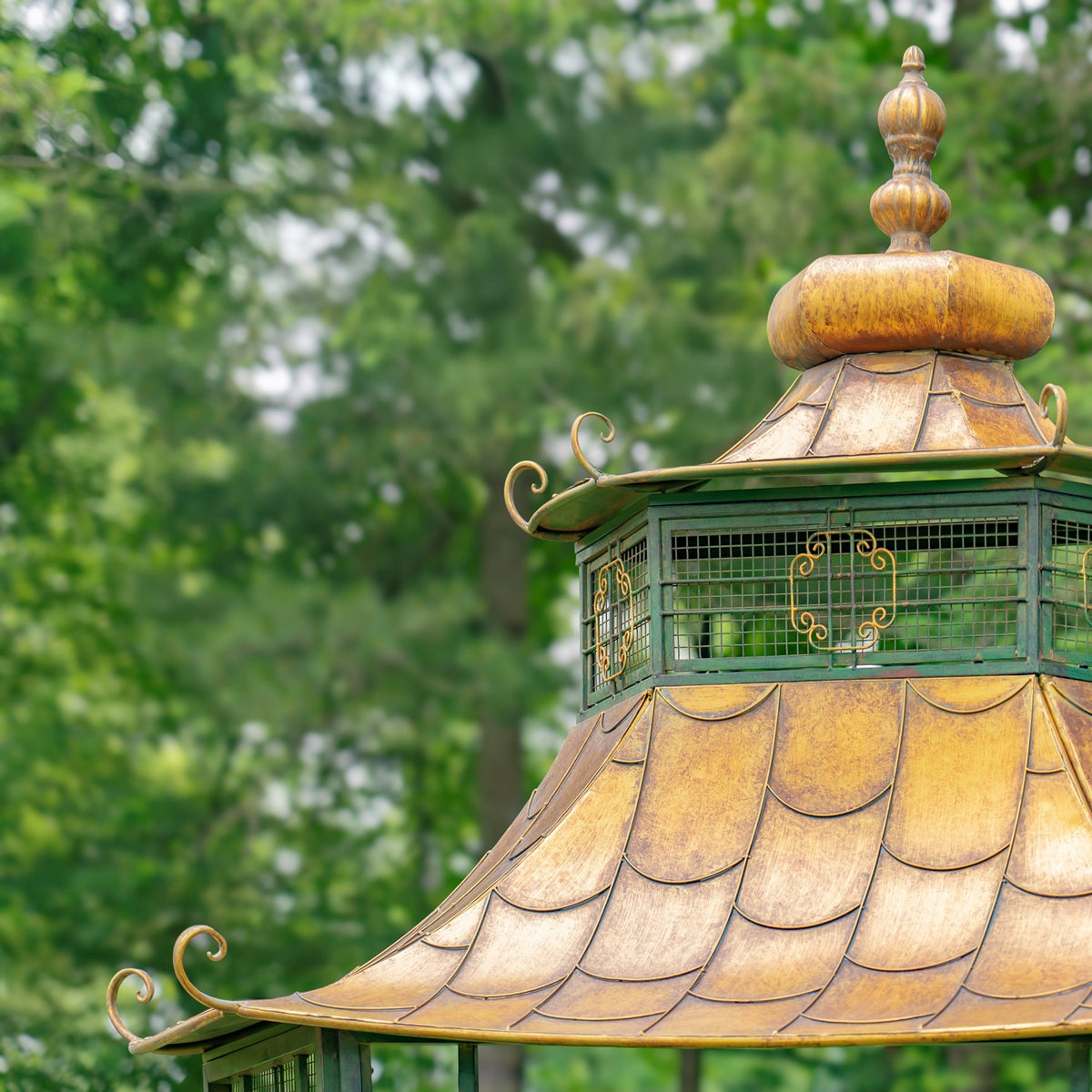 Pagoda-style roof with layered gold-toned panels, curled eaves, and a large rounded finial.
