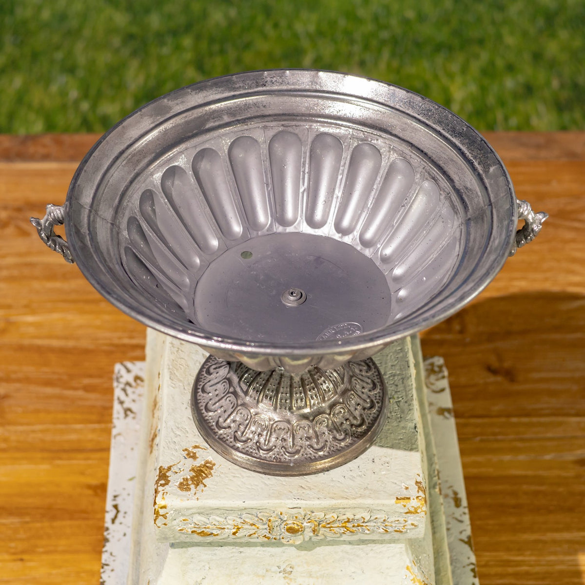 View into the urn’s empty fluted bowl, with its pedestal base visible below.