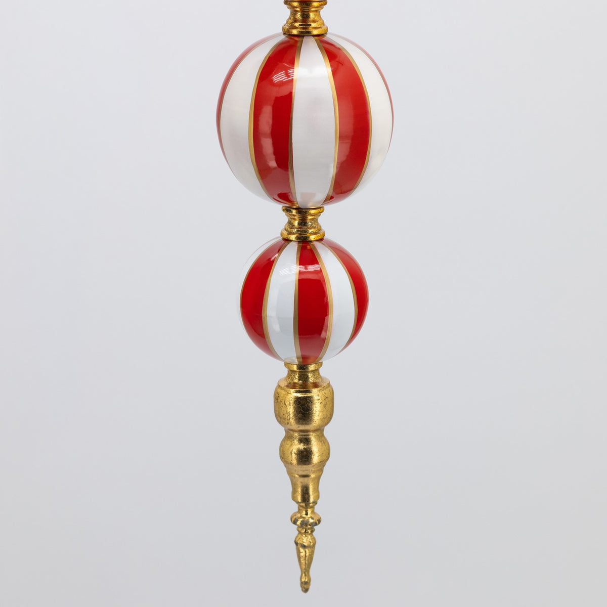 Red and white striped spheres joined above an ornate gold-colored pointed finial.