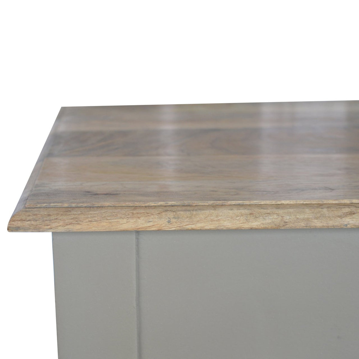 Close-up view of the stained wood desk top edge and painted base