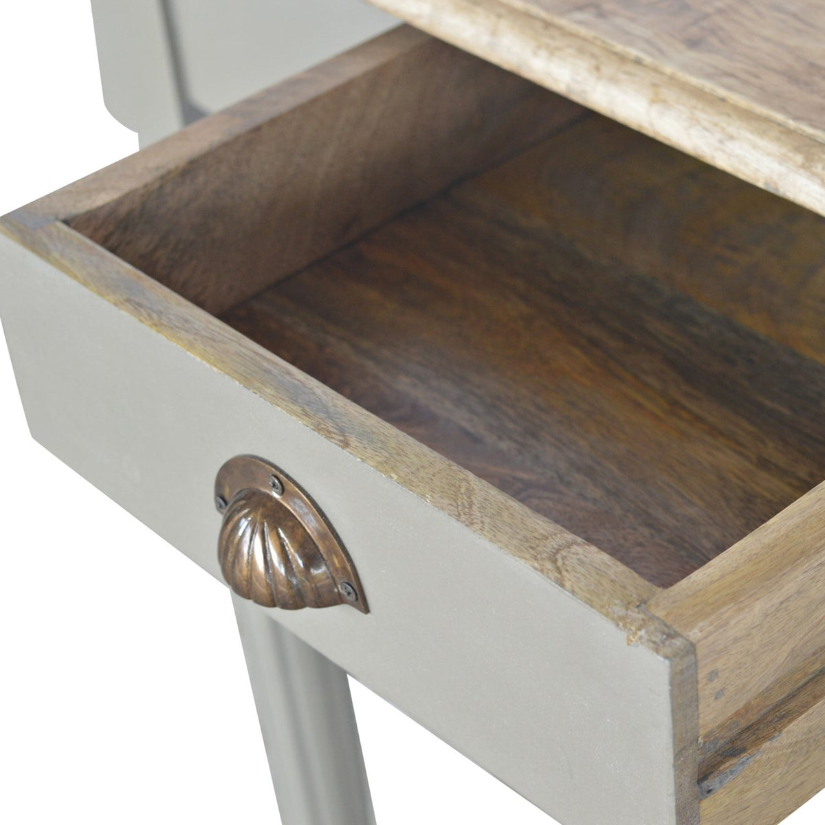 Open desk drawer showing its wood interior and shell-shaped handle