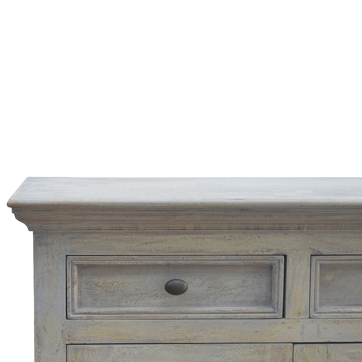 Detail view of the sideboard's pale weathered top and a framed drawer front