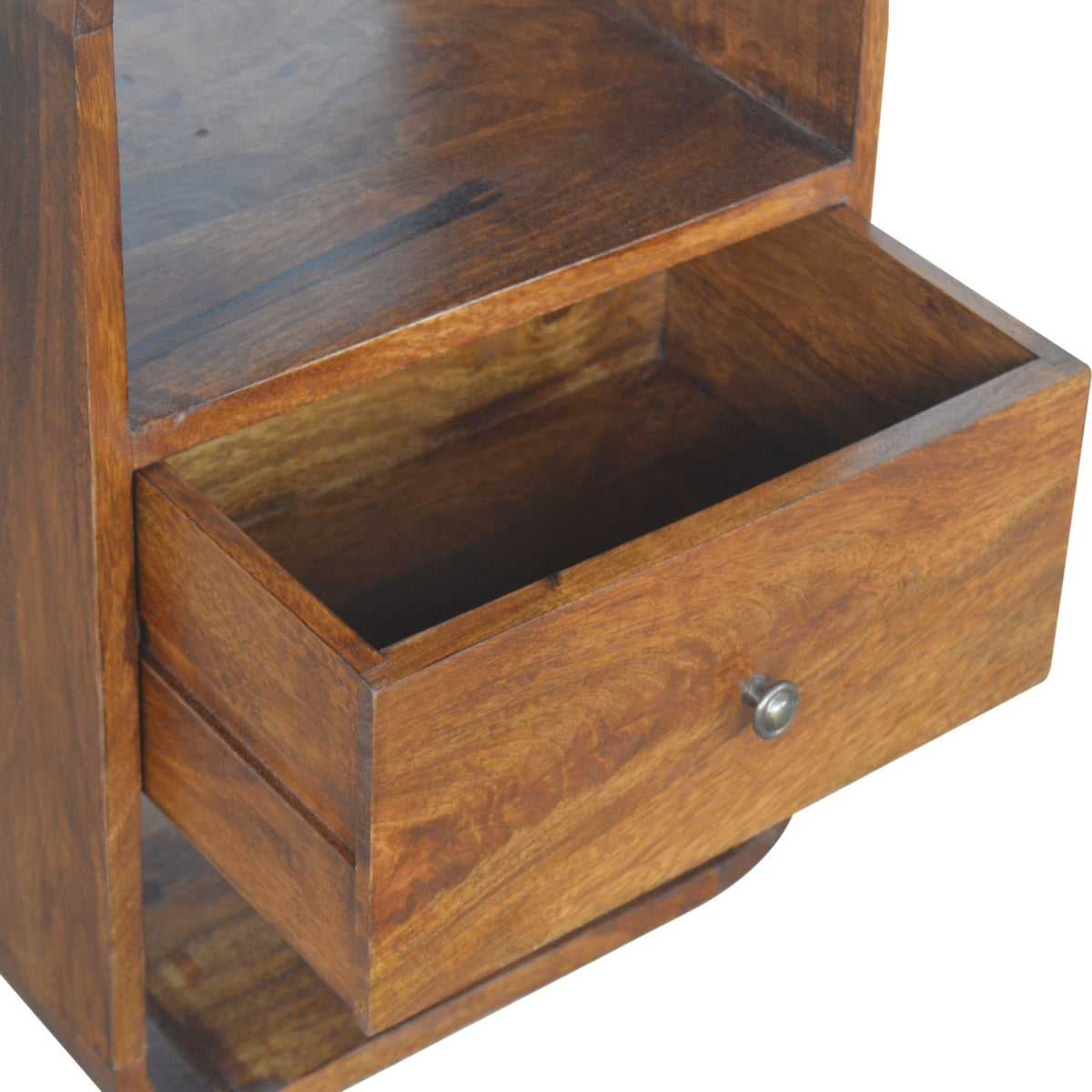 Close-up of an open nightstand drawer beneath the upper open storage slot