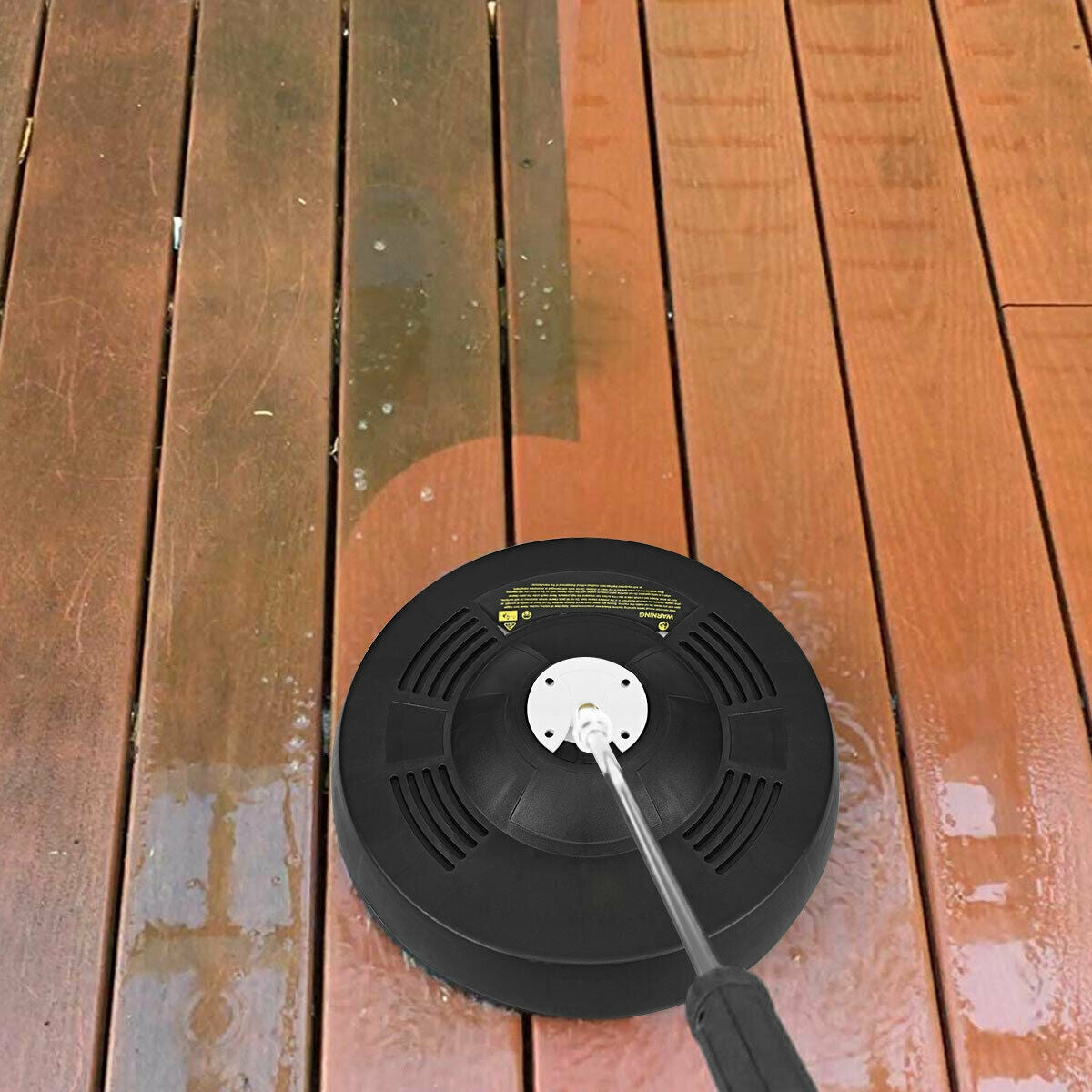 The cleaner moves over deck boards, leaving a darker wet path beside lighter boards.