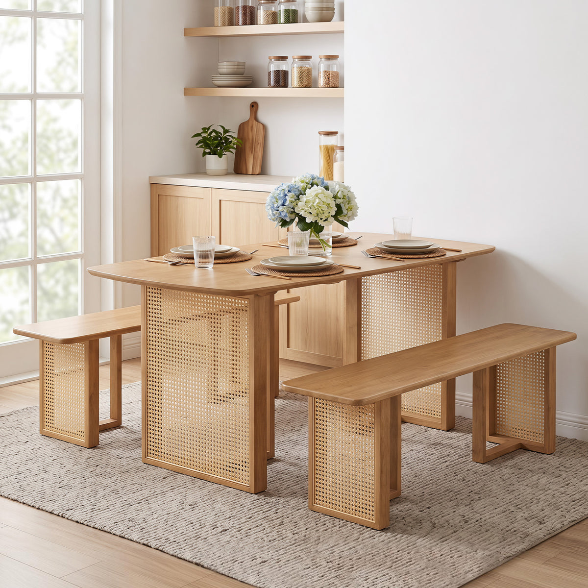 Dining set arranged on a rug, with two long benches and woven-look table supports.