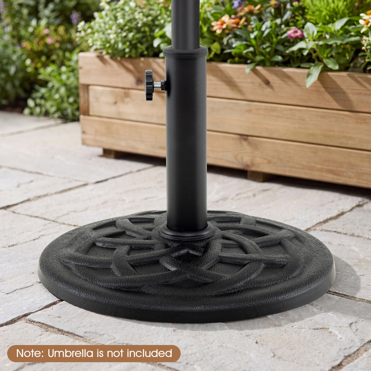 Black round umbrella base with a central pole and tightening knob on a stone patio.